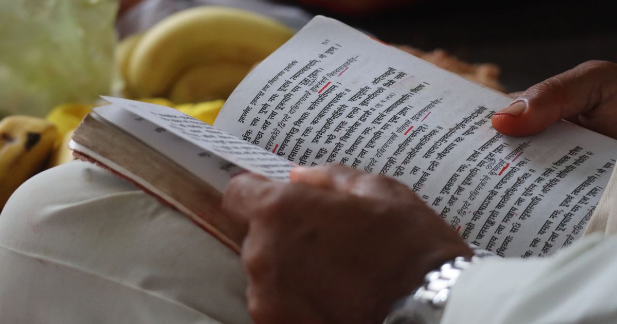 Person reading the Bhagavad Gita during a quiet moment of reflection and spiritual study.
