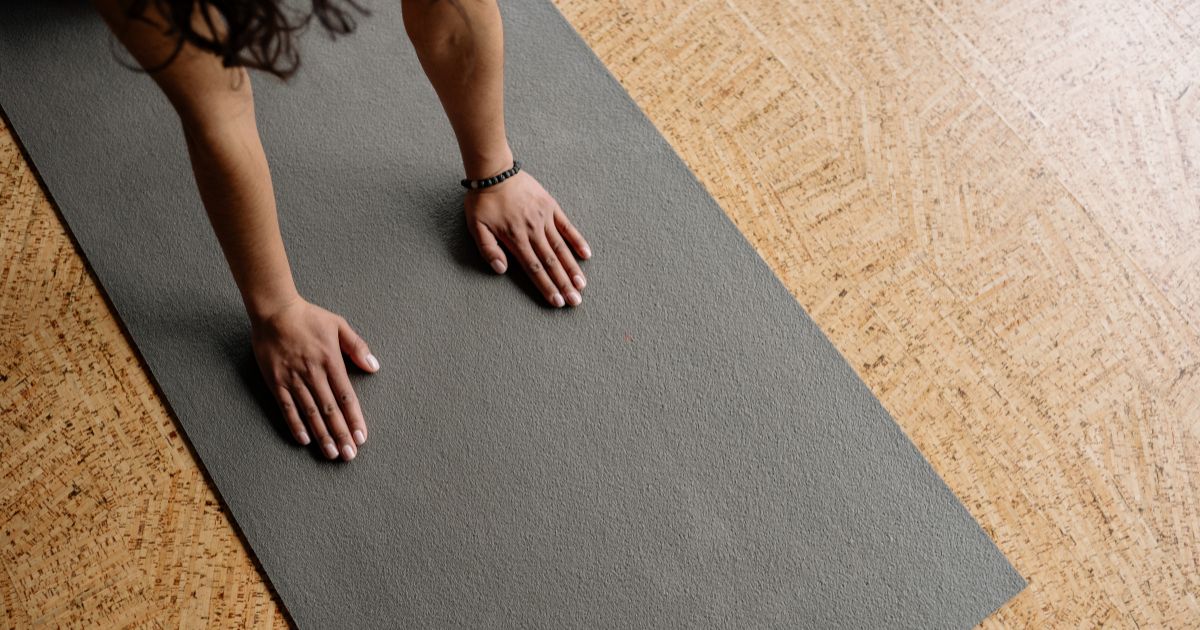 Person practicing yoga on a mat, representing the chakra system and mindful movement.